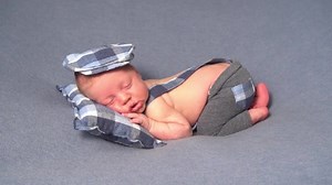 Newborn baby boy lying on bed, sleeping, close up