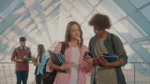 Two Attractive Students Talking and Using in the College Hallway. Digital Education. Future Technologie. Teamwork