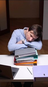 vertical Exhausted office worker sleeping on documents at desk