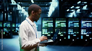 African american engineer inspecting interlinked computers creating server network. High tech facility using parallel computing to perform complex calculations and process large amounts of data