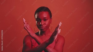 No racism. Protest X gesture. Stop discrimination. Red neon color light dissatisfied strict woman rejecting with crossed hands isolated on dark bright gif loop boomerang animation.