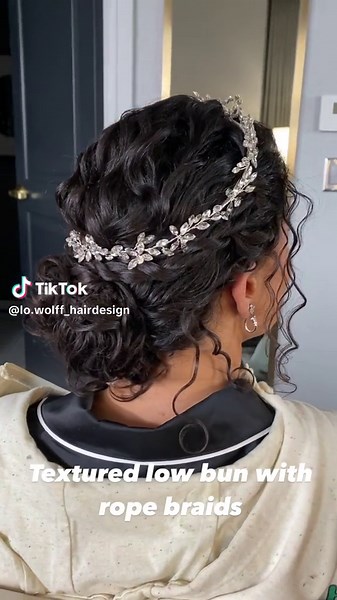 Updo inspiration for curly hair clients & queens 👑 This bride was blessed with gorgeous natural curls. The vision was to create a textured low bun with rope braids (right below her hair accessory). We combined 2 accessories, a tiara & a vine, to create this magical crown. She was a real life princess! I used my @mizani gel to create the rope braids & combat frizz. And my 3/4” curling iron to enhance a few curls at the crown of her head (other than that, I didn’t not use heat on her natural curl