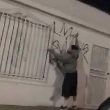 Lopez MaraVilla gang member tagging up a wall.