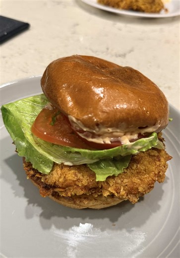 High protein chicken sandwich using cornflakes as the breading🔥 Using the standard three-step breading process involves coating food in flour, then egg white wash, and finally crumbs. I added hot sauce to the egg whites. Sauce is made with Greek yogurt, light mayo, siracha, garlic powder, onion powder and paprika! Let me know if you’d try this delicious and juicy air fryer chicken sandwich! #chicago #highprotienchickensandwich #chicagotiktok #healthyeats #chickensandwhich