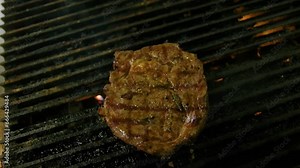Grill master flips steak showcasing beautiful grill marks cooking over propane gas flame