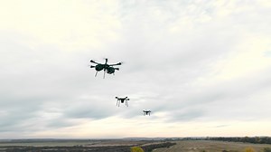 Combat military drones fly on the sky background.