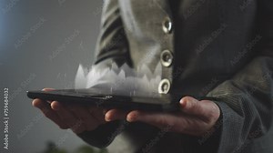 Cg footage on the topic of financial information analytics. A businesswoman holds a graphics tablet in her hands above which graphs and charts grow and move