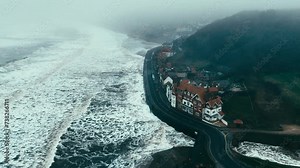 Stormy winter scene. Rough seas of the English coast with mist and fog. Aerial footage of the sleepy coastal town of Sandsend beach on the coast of north Yorkshire in England