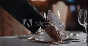 Woman carefully setting an upscale table