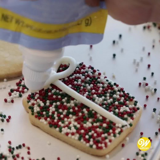 This easy Christmas present cookie uses our roll-out cookie dough recipe, then decorated with white icing and sprinkles! Find the instructions here: http://ow.ly/S0fQ50CBSTC | Wilton Cake Decorating