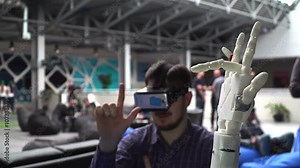 Cybernetic robot arm, which controls the people. Man controls robotic arm through virtual reality glasses. Playing the game or the game lives in another world. Hand as the Skynet Stock Video