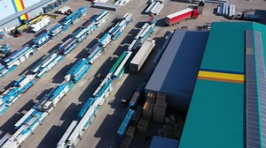 Aerial view of a semi trucks with cargo trailers standing on warehouses ramps for loading unloading goods on the big logistics park with loading hub Premium Stock Video Footage
