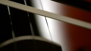Close up of a bow being pulled across a cello - Free Stock Video