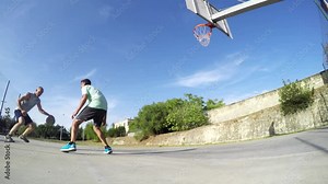 Two guys playing basketball on a clear summer day