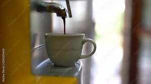 Aromatic black espresso pouring from professional coffee machine in bar. Barista man making double espresso using coffee filter. Fresh ground coffee pouring inside white cup. Coffee drops concept
