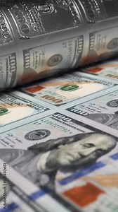 100 USA dollars banknotes are being printed by currency press machine. Close up background showing a process of american bills printing. Loop video of money printing process. Vertical, phone wallpaper