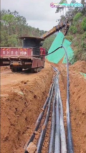 Laying outdoor power cables using an integrated transport, pay-off and laying vehicle
