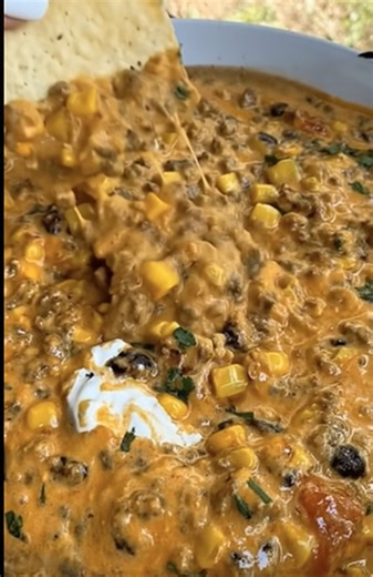 Tex-Mex Beef Queso Dip – In a skillet over medium heat, brown the ground beef until fully cooked. Drain excess grease. Add diced onion and jalapeño (if using) and cook 2–3 minutes until softened. Stir in taco seasoning and a small splash of water. Simmer 1–2 minutes until thickened. Reduce heat to low and add cubed Velveeta (or processed cheese) and a splash of milk. Stir continuously until the cheese is fully melted and smooth. Mix in diced tomatoes with green chilies (drained) and a handful of