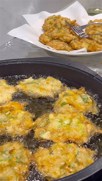 🫶NONNA’s Zucchini Fritters Recipe🫶 🌿INGREDIENTS 🌿 *Serves 15-20* 1 medium sized white flesh zucchini 5-10 Zucchini flowers (optional) 2 cups of vegetable oil (roughly) 2x eggs Half a TBSP of dry yeast 1 cup 1/4 of plain flour 1/3 cup of parmesan cheese 1x bunch of basil (leaves & stems) chopped 1x cup of water Salt 🥒DIRECTIONS🥒 1. Cut up your zucchini into small pieces as per video. Add to a bowl with a large pinch of salt, mix through with hands and cover with plastic wrap. Let these sit 