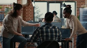 System engineer sitting on desk discussing with mixed team of coders about ai innovation in front of multiple screens compiling code. Programmers doing teamwork looking at machine learning algorithms.