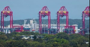 Huge cranes moving Containers, loading and unloading at shipping port. Heatwaves