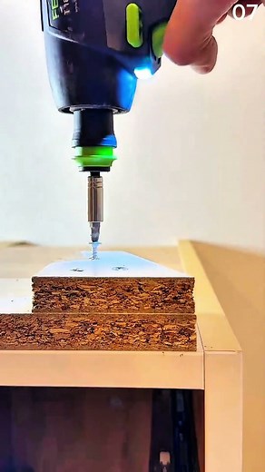 Installing screws using an electric screwdriver on particle board