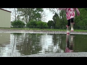 Puddle Jumping - Little Girl Splashing Camera. Stock Footage