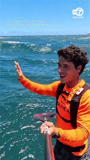 Whale breaches right next to surfer