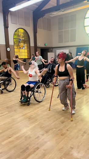 AXIS Dance Company on Instagram: "When access is part of the foundation, the floor is open to every dancer. 📍 This moment from our AXIS Summer Intensive hip hop class shows how integrated dance opportunities make space for every body to learn, create, and move together. Video description: A large, bright dance studio with yellow-tinted arched windows and high ceilings. A mixed group of disabled and non-disabled dancers, including wheelchair users and dancers with standing support, move together