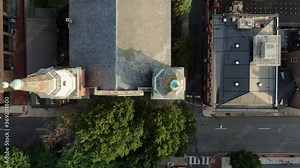 Top down aerial birds eye perspective of two copper church steeples in downtown city of USA