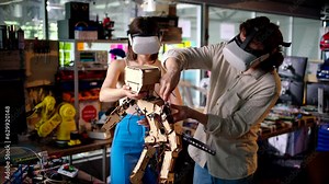 Two young engineers fixing a mechanical robot in the workshop, using VR virtual reality headsets