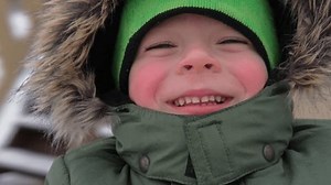 Happy Kid Having Fun on Carousel. Front View of Smiling Little Boy Enjoying an Merry-go-round Attraction. Amusement Kiddie Ride. POV. Carefree Young Child Spinning at Playground Carrousel Closeup Face
