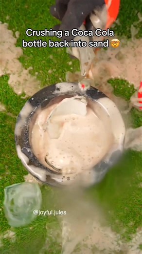 Coca cola bottle back into sand