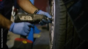 Mechanic tightening wheel nuts on a vehicle in a garage Stock Video