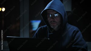 Hacker in a dark room, writes malicious code. An experienced programmer works alone.