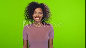 Curly optimistic dark skinned woman raises palms from joy happy to receive awesome present from someone shouts loudly, dressed in casual t-shirt, on chromakey background. Excited Afro female yells