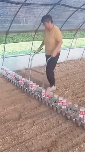 A man is digging a hole in the ground using a large number of bottles.