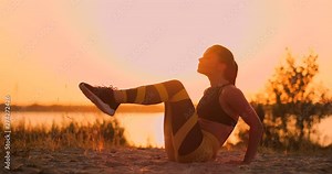 Fitness woman doing crunches at the beach. Fitness woman doing crunches exercise workout towards the beach. Female fit athlete training abdominal midsection.