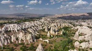 Cappadocia landscape view. Turkey. Goreme National Park. Drone footage of red valley rocks formations called the Fairy Chimneys. Open air museum aerial shot of city and houses from caves