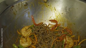 Cooking Chinese Food With Tasty Shrimp Ingredient In A Steel Wok Pan. Delicious Cooking Of A Chinese Wok Noodles Food With Vegetables At A Restaurant Kitchen. Professional Cooking Fresh Chinese Food.