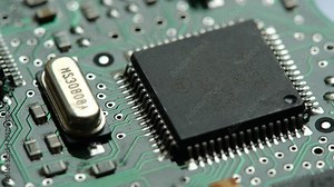 Small microprocessor, microcontroller chip on a generic modern desktop PC computer motherboard, object macro, extreme closeup, zoom in, nobody Electrical components shortage concept, circuit board