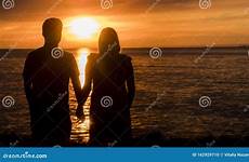 sunset silhouettes enjoying standing couple sea near young preview