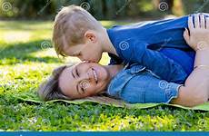kissing son mother park young playing whilst rug stock cheek outdoors sitting together preview