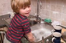 washing dishes sink doing child boy kitchen toddler alamy hot