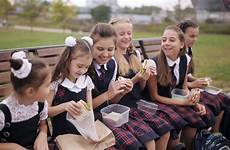 girls school college eating student uniform wearing park same resting sandwiches smiling while
