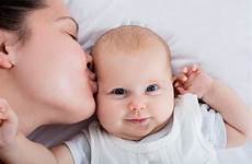 baby kissing her mother forehead close