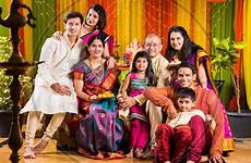 family indian happy celebrating ganesh festival traditional chaturthi eating pooja performing sweets welcoming picxy related wear