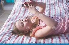 lying back bed her teenage phone girl looks
