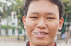indonesian boy man young portrait stock teenage vertical jacket wearing strap chest smiling across camera looking red alamy