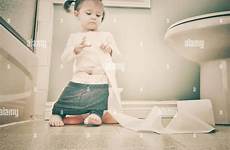 toilet girl sitting potty toddler young stock playing paper roll alamy